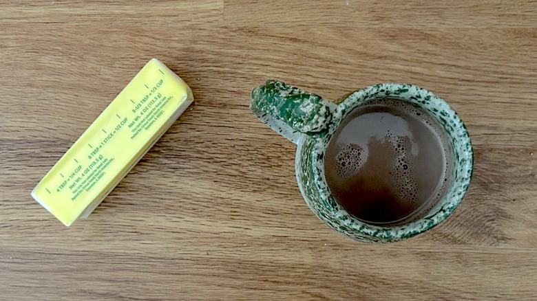Stick of butter and hot chocolate in a green mug