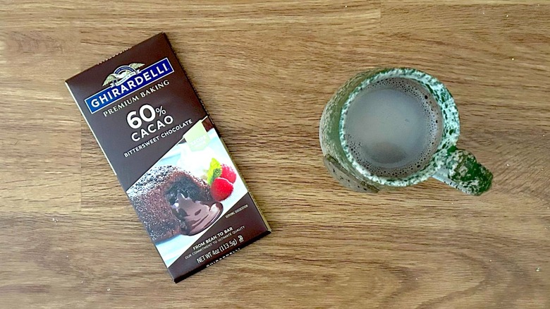 Bar of Ghirardelli 60% Cacao Bittersweet Chocolate and hot chocolate in a green mug