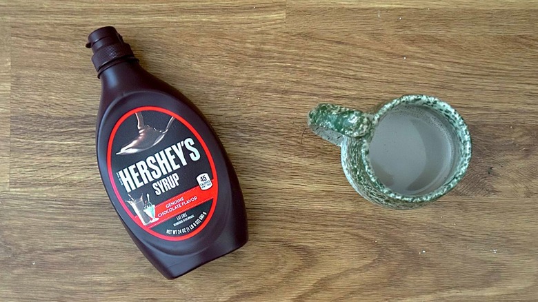 Hershey's Chocolate Syrup and hot cocoa in a green mug