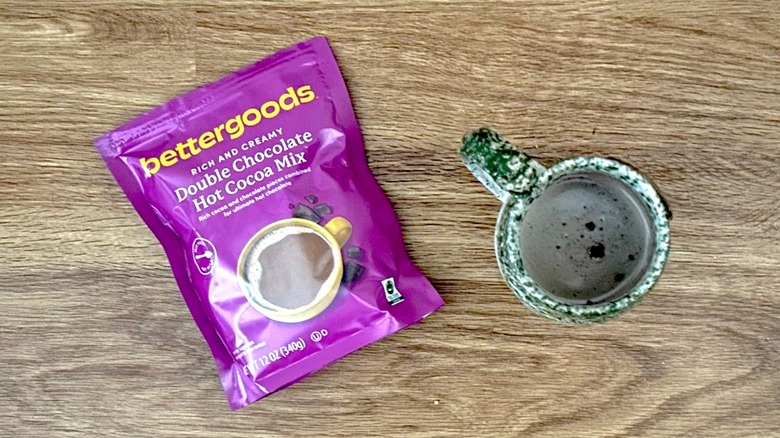 Package of bettergoods Instant Hot Cocoa Mix and hot chocolate in a green mug