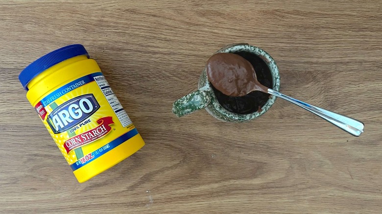 Container of cornstarch and thick hot chocolate in a green mug