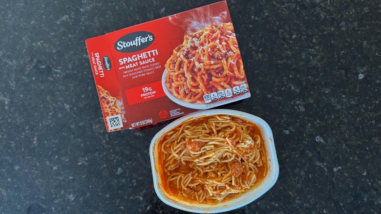 Package and tray of Stouffer's Spaghetti with Meat Sauce on black countertop