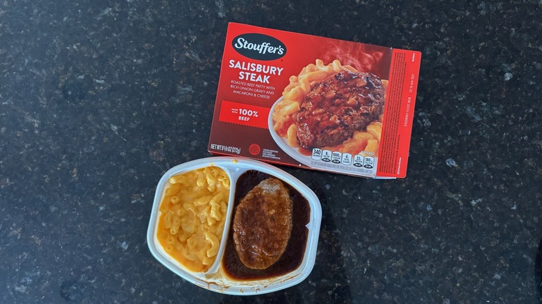Package and tray of Stouffer's Salisbury Steak on black countertop