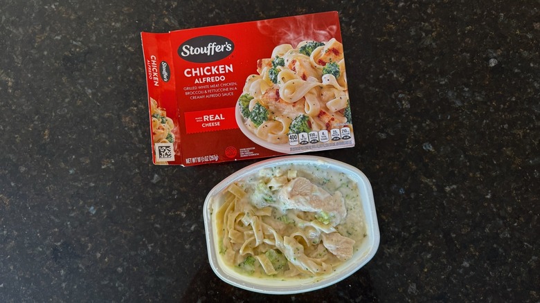 Package and tray of Stouffer's Chicken Alfredo on black countertop