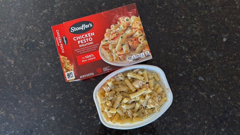 Package and tray of Stouffer's Chicken Pesto Rigatoni on black countertop