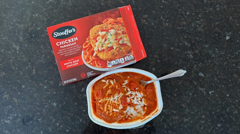 Package and tray of Stouffer's Chicken Parmesan on black countertop