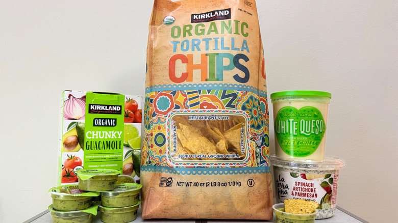 Large bag of Kirkland Signature Organic Tortilla Chips surrounded by various packages of dips