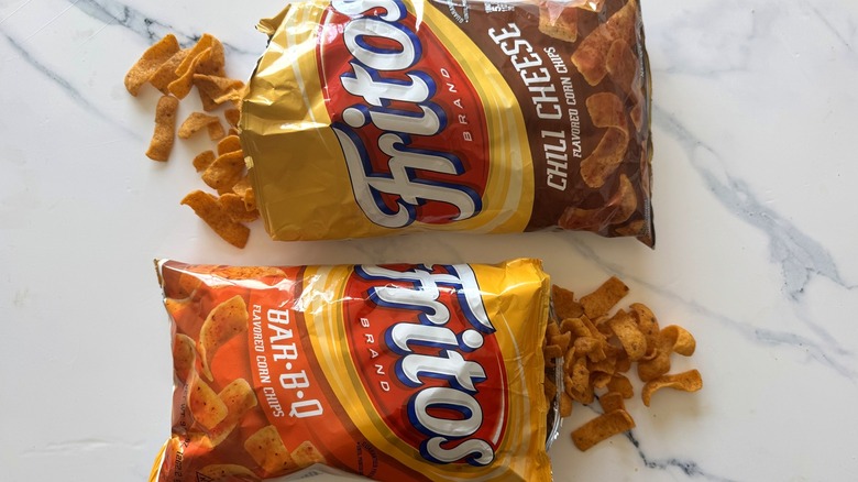 Two bags of Fritos facing opposite directions on marble surface