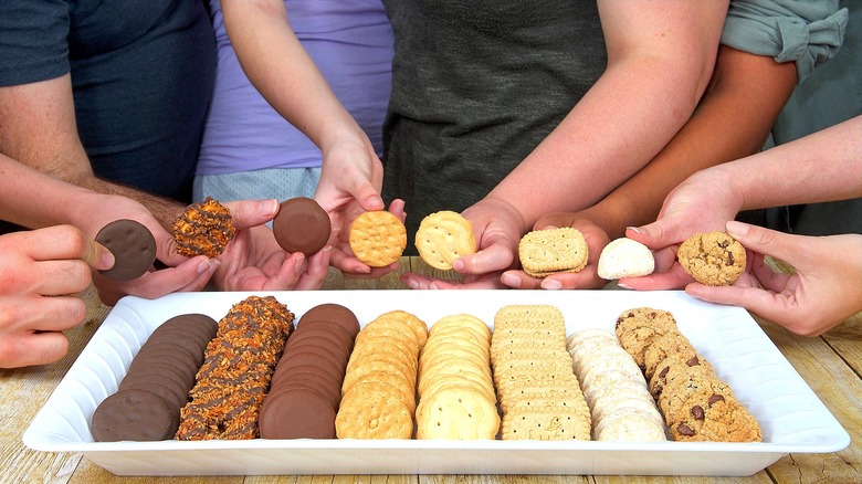 Eight unboxed varieties of Girl Scout cookies lined on a white tray