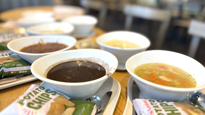 Panera soups lined up with potato chips on the side of each bowl