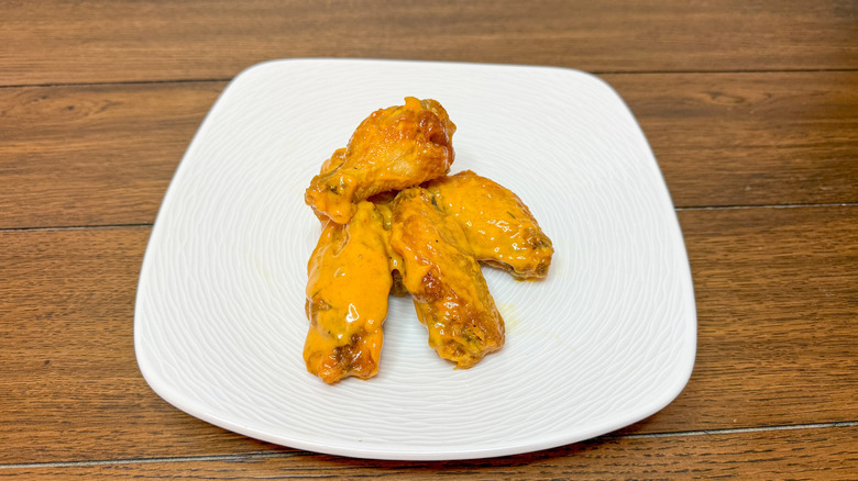 Chicken wings stacked on white plate