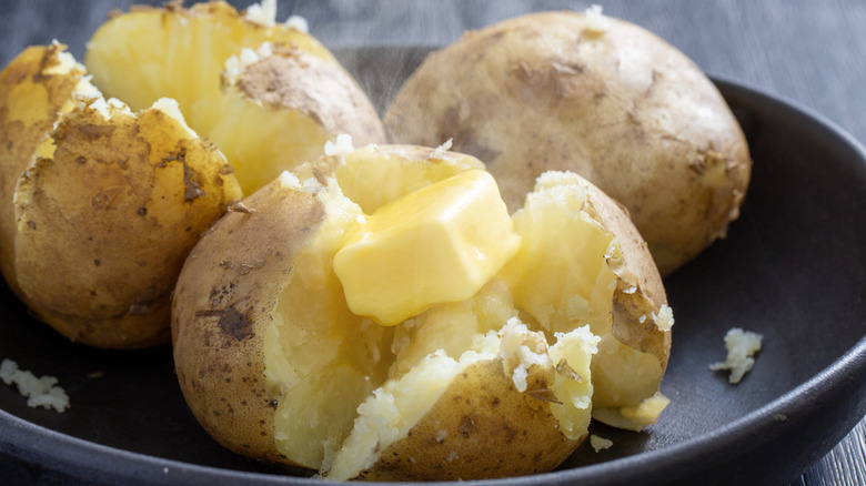 three baked potatoes in dish