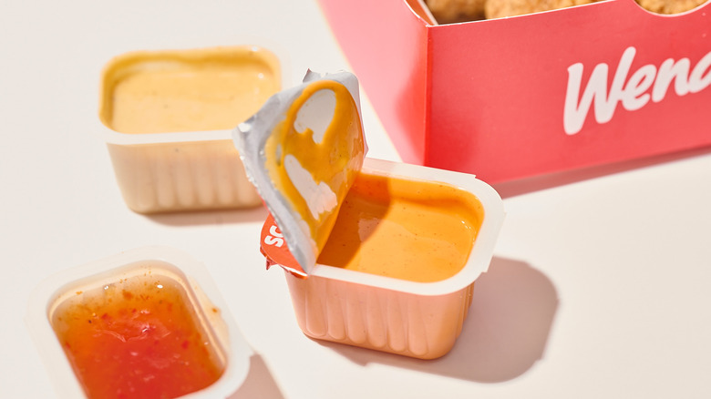 Wendy's hot sauce opened and on a table