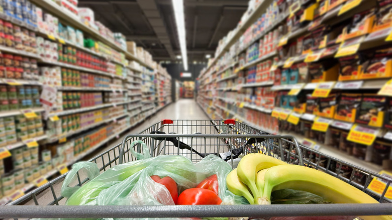 A picture of a cart going down a supermarket aisle