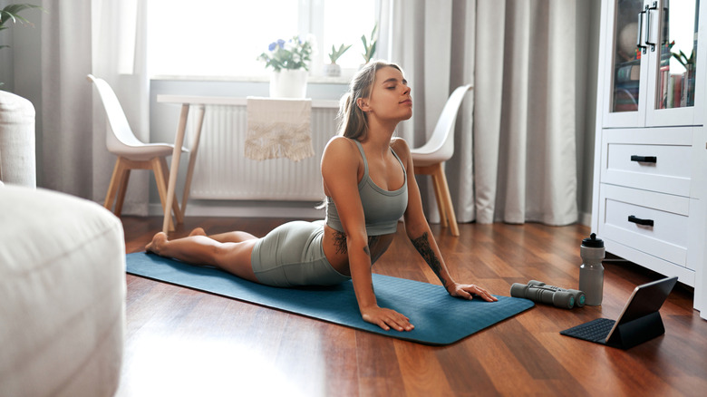 Woman in yoga pose at home on mat