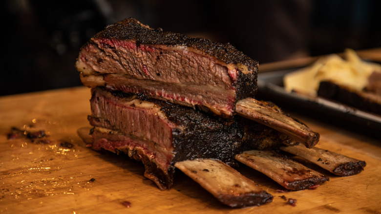Dino plate ribs with one rib cut and stacked on top of the rest of the rack to show off its juicy interior
