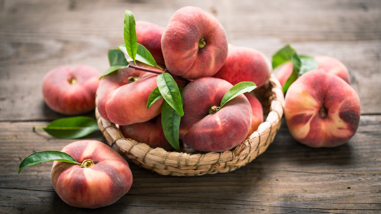 Basket of donut peaches on a wooden table