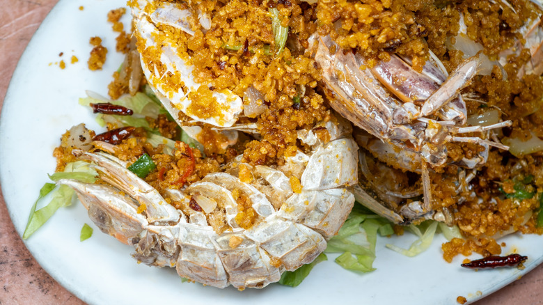 Fried mantis shrimp on white plate with lettuce.