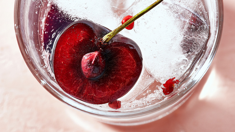 Gin and tonic with pink peppercorns and cherries