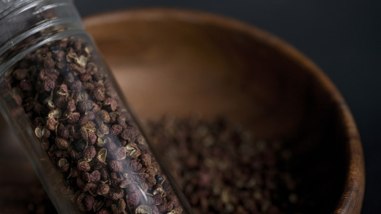 A grinder filled with Sichuan peppercorns