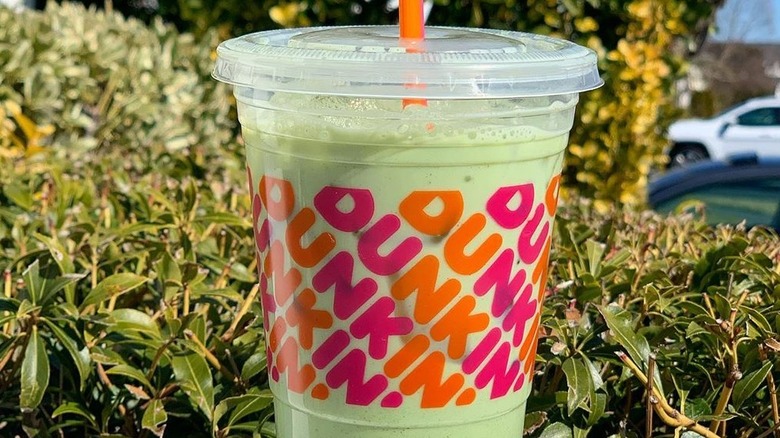 Dunkin' iced matcha latte in plastic cup with straw