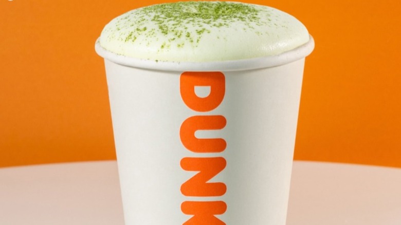 Dunkin' hot matcha latte with matcha sprinkles on white foam