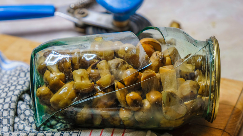 A broken jar of canned mushrooms