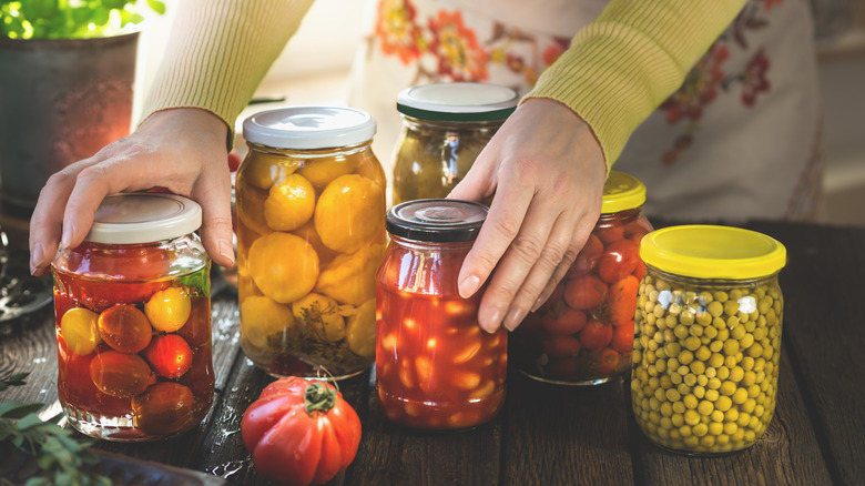 A women with several jars of preserved food