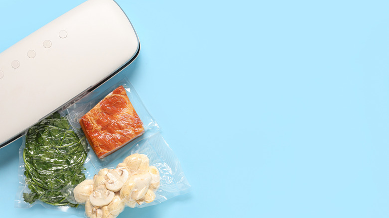 Vacuum sealer machine with sealed packs of meat, greens, and mushrooms