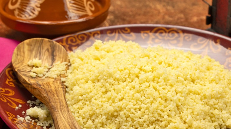 Plate of couscous with a wooden spoon