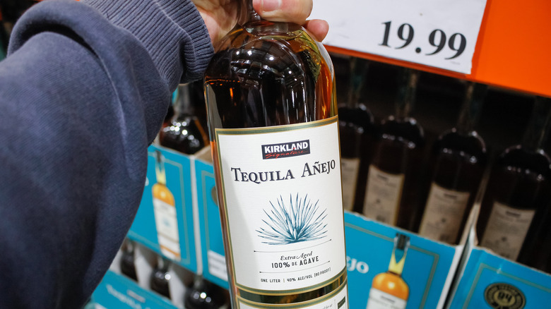 Hand holding Kirkland Tequila Anejo from Costco 