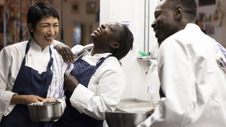 Three kitchen staff sharing a laugh