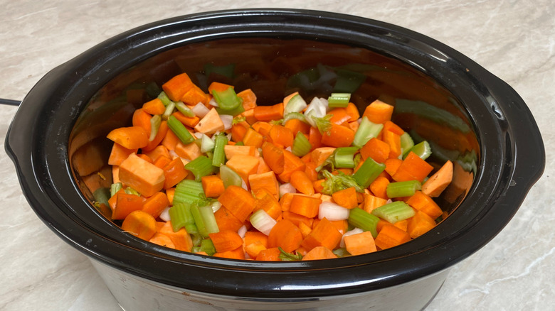 High angle image of roughly chopped mirepoix in a slow cooker