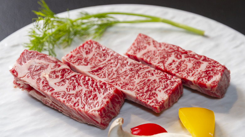 Three pieces of Kobe beef on a white plate