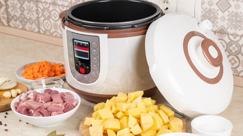 instant pot surrounded by chopped stew ingredients