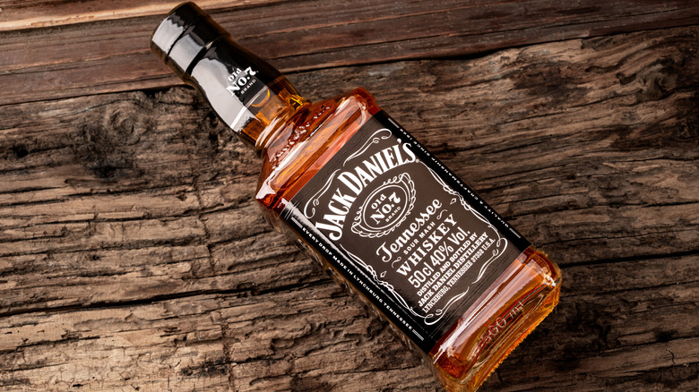A bottle of Jack Daniel's No 7 lying on a wooden surface.