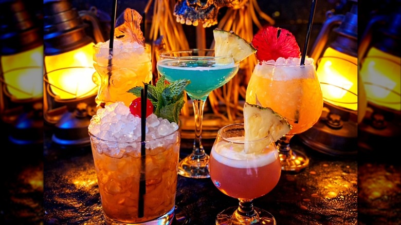 Assorted cocktails in glasses on a brightly lit cocktail bar at The Golden Tiki
