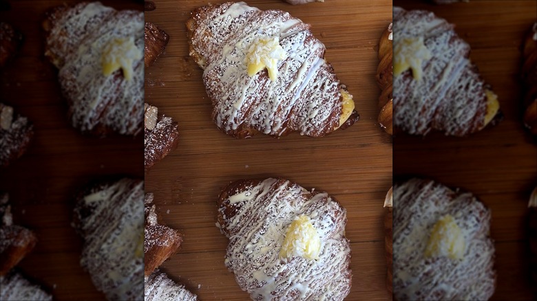 Freshly baked coconut croissants with powdered sugar from Délices Gourmands