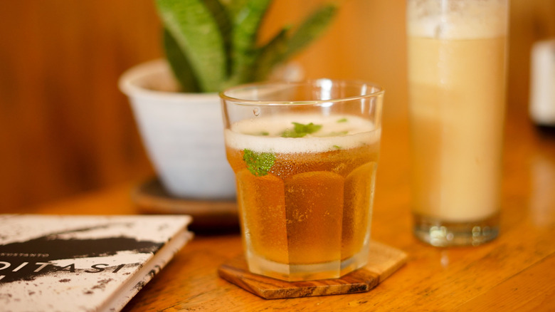 A cup of fizzy kombucha topped with garnish