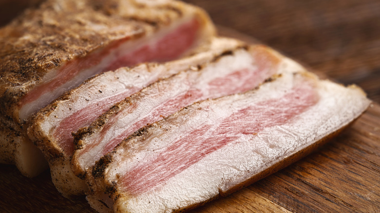 Pork jowl cooked and placed on a wooden board