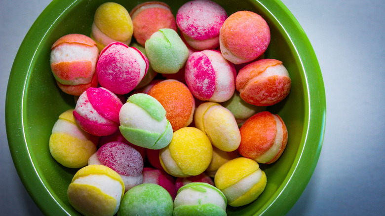 a green bowl filled with freeze dried candy