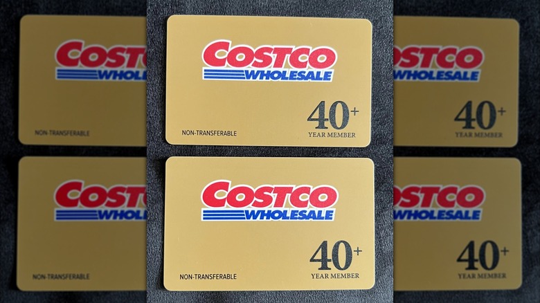 The membership desk inside of a Costco store with a large sign showing the different types of memberships available.