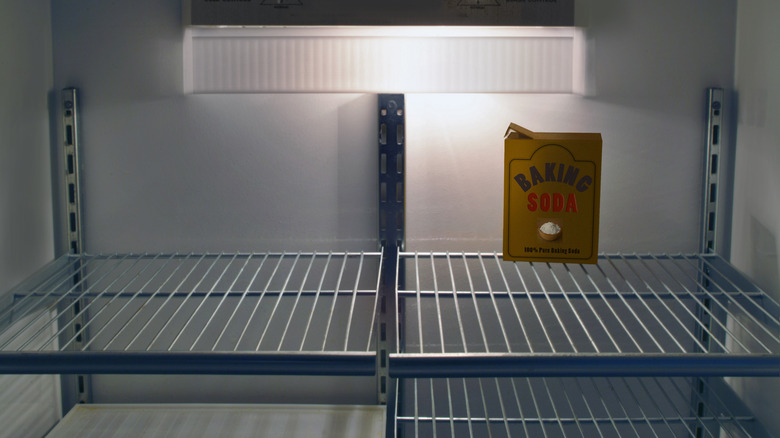 A box of baking soda in an empty fridge.