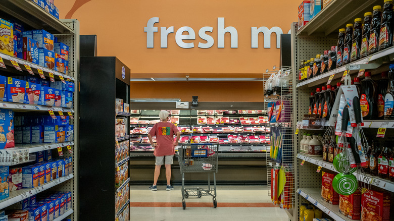 A view down an aisle at Kroger, with the meat section at the end.