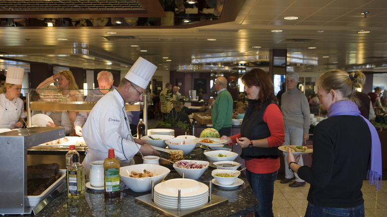 Cruise ship passengers selecting food at a buffet.