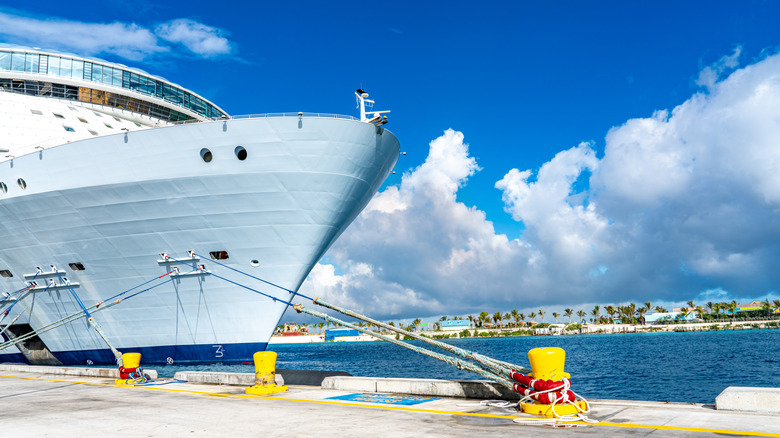 The front of a cruise ship docked in a port.