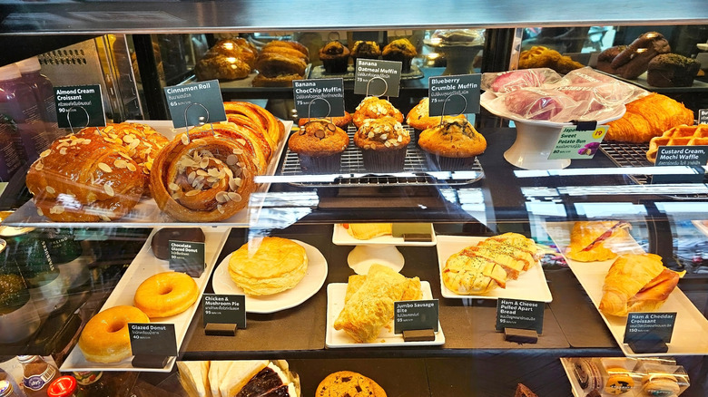 A vibrant display of assorted baked goods at Starbucks, including pastries, muffins, and donuts, arranged in a glass case