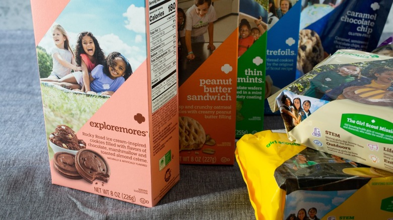 Several boxes and packages of Girl Scout cookies of varying flavors.