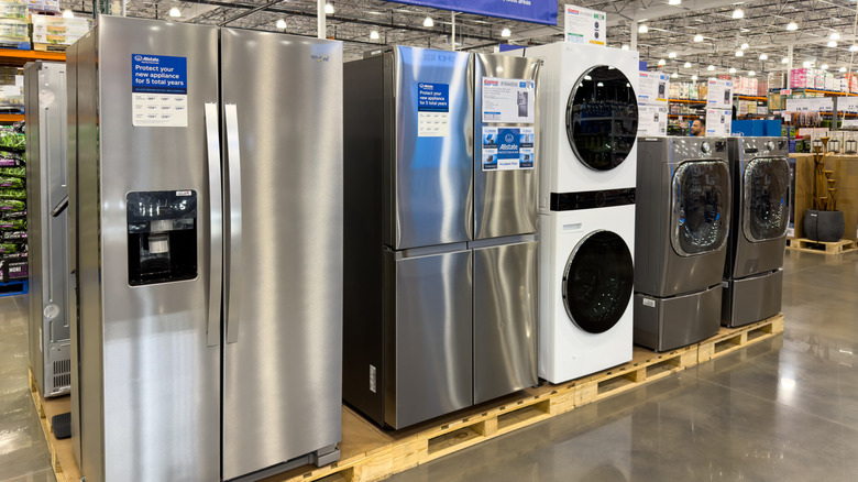 Refrigerators and washing machines on display inside a Costco store.