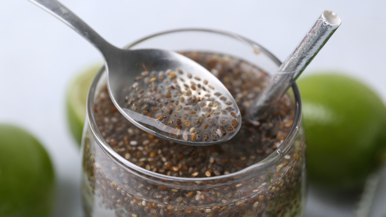 Chia seeds submerged in liquid with a spoon scooping them up